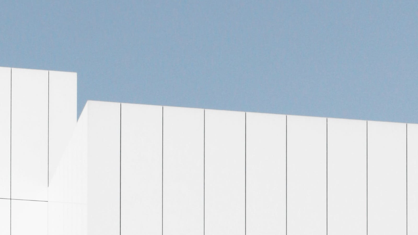 Clean white fence against blue sky