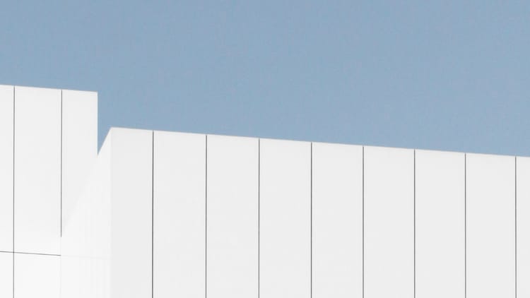 Clean white fence against blue sky